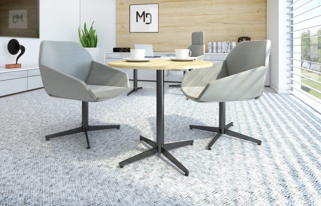 W nowoczesnym biurze przy okrągłym stole, złożonym na stelażu składanym do stołu, stoją dwa szare krzesła.